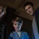 The three Locke siblings from Netflix's Locke & Key stand over something and look down into it fearfully.